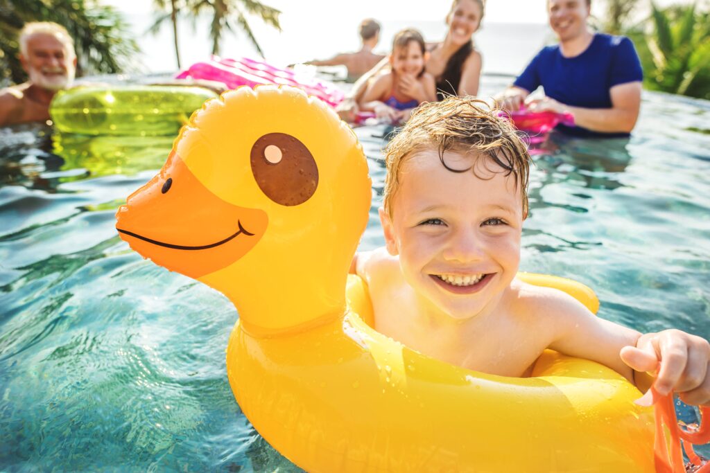 Young Boy Swimming in a pool during summertime.